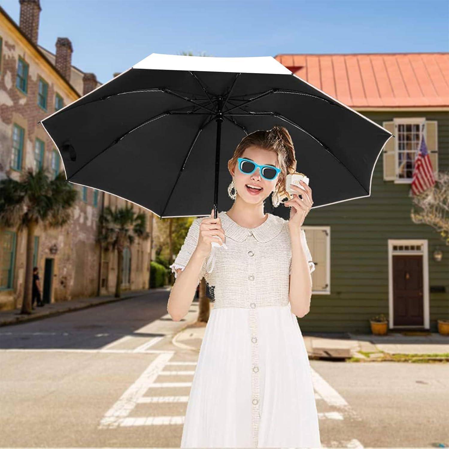 Eine Person mit Sonnenbrille hält eine Eiscreme und einen schwarzen Regenschirm und steht auf einer sonnigen Straße mit historischen Gebäuden und Palmen.