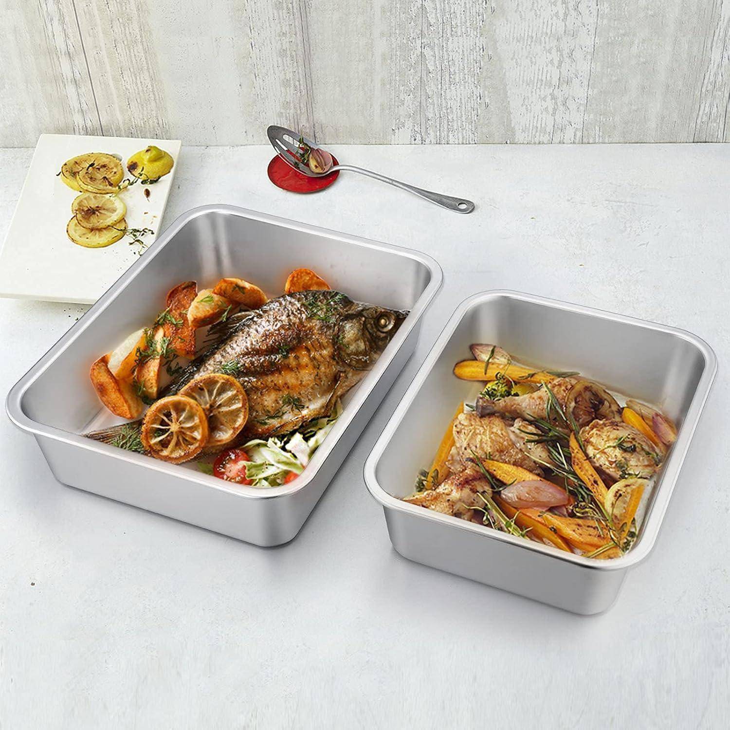 Zwei Metalbackbleche mit ganzen gebackenen Fischen. Ein Blech enthält einen Fisch mit Zitronenscheiben und Kräutern, das andere mit Fisch und Gemüse.