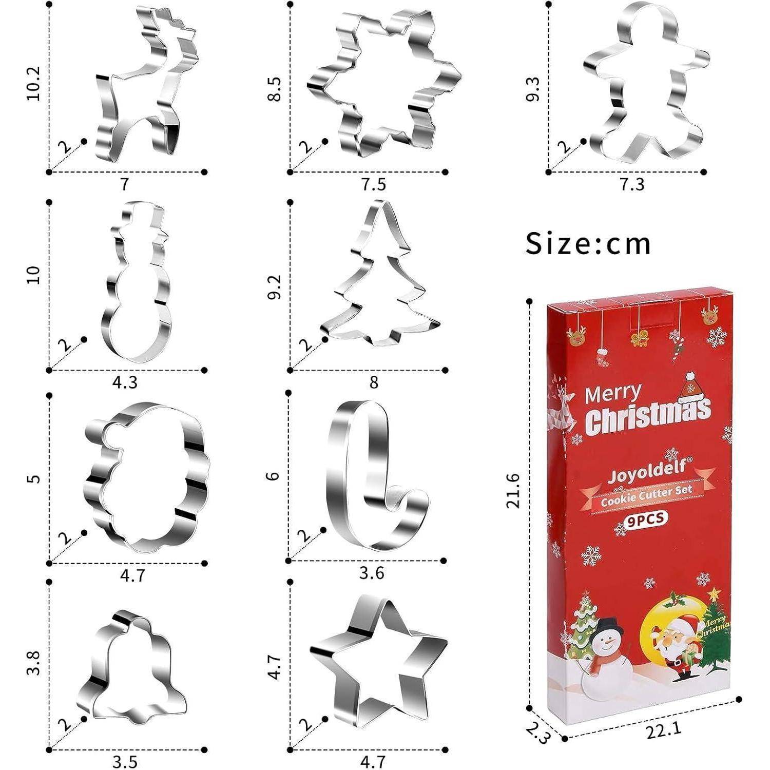Neun weihnachtlich gestaltete Metallausstechformen in verschiedenen Formen neben einer roten Schachtel mit der Aufschrift 