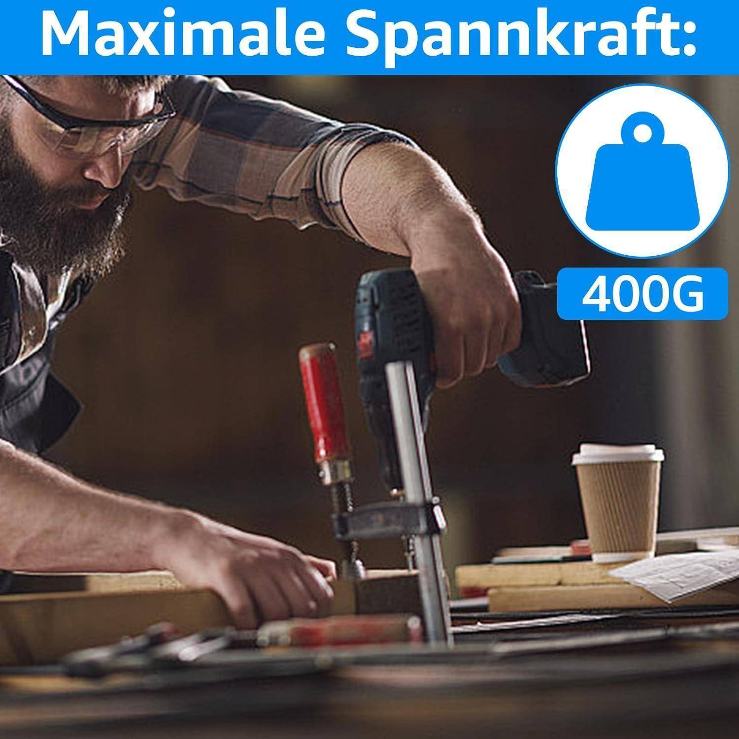Eine Person mit Brille justiert eine Klemme in einer Werkstatt. Das Bild enthält den Text 'Maximale Spannkraft: 400G' mit einem Gewichtssymbol.