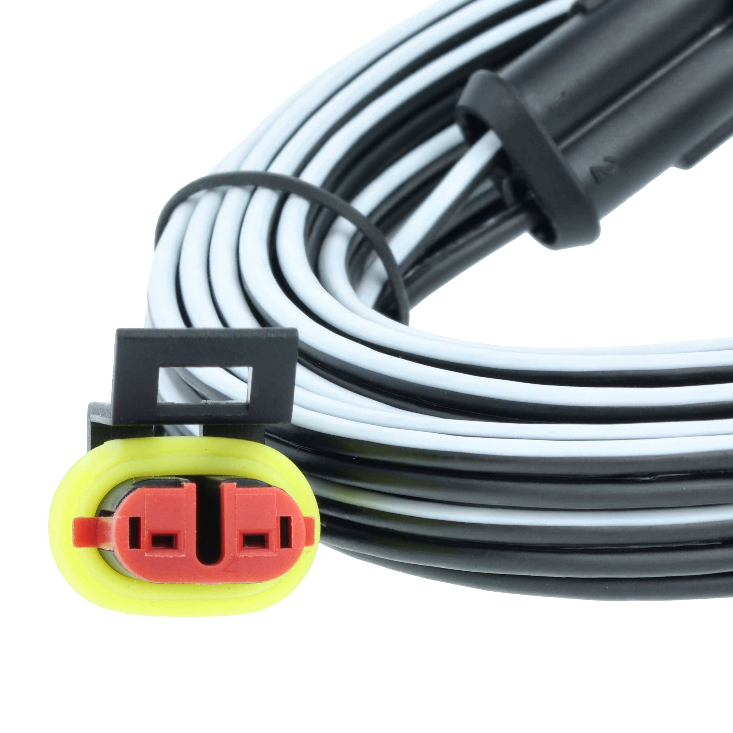 Ein gewickelter schwarzer und weißer Kabel mit einem gelben und roten Stecker am Ende, wahrscheinlich für elektrische oder automotive Zwecke verwendet.