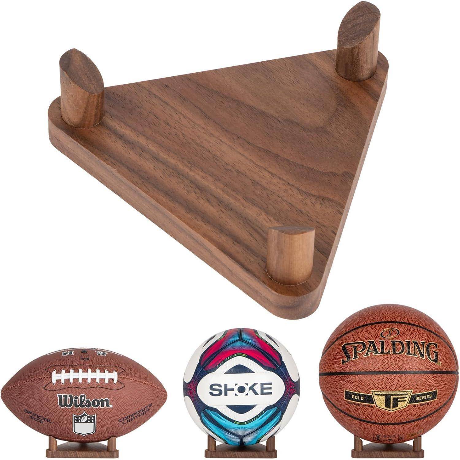 Ein Holzregal mit drei Fächern, in denen jeweils ein Ball liegt: ein American Football, ein Volleyball und ein Basketball.