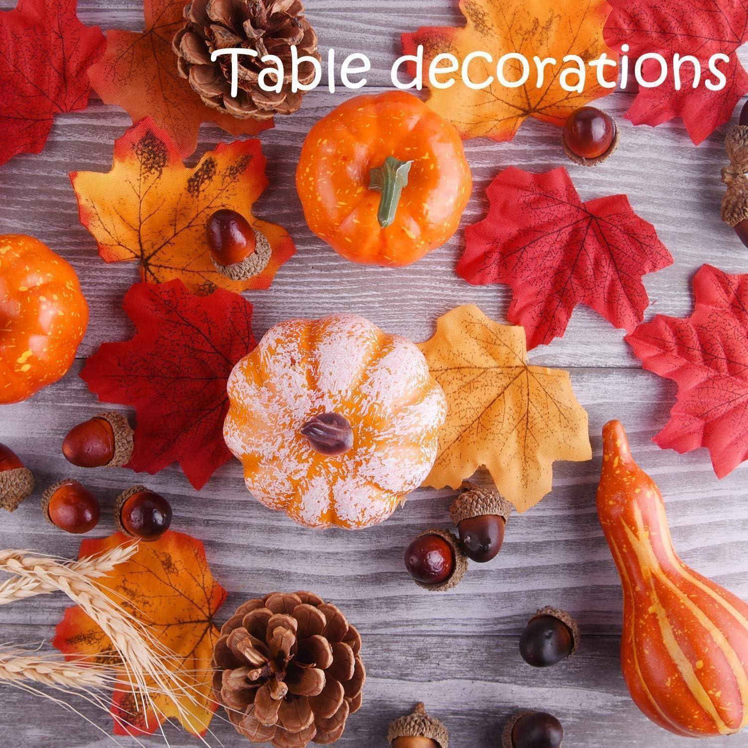 Herbstliche Tischdekoration mit Blättern, kleinen Kürbissen, Tannenzapfen und Eicheln, die auf einer Holzoberfläche angeordnet sind.