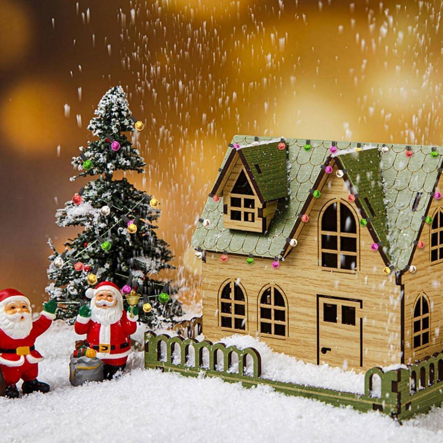 Weihnachtsmännchen und ein schneebedeckter Weihnachtsbaum neben einem Lebkuchenhaus, das mit bunten Lichtern geschmückt ist.