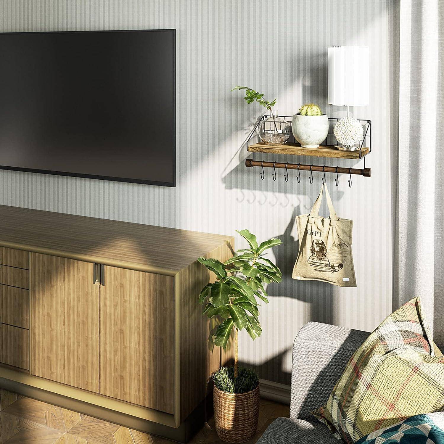 Ein modernes Wohnzimmer zeigt einen an der Wand montierten Fernseher, einen Holzschrank mit einer Topfpflanze und ein Regal mit Dekoartikeln darüber.