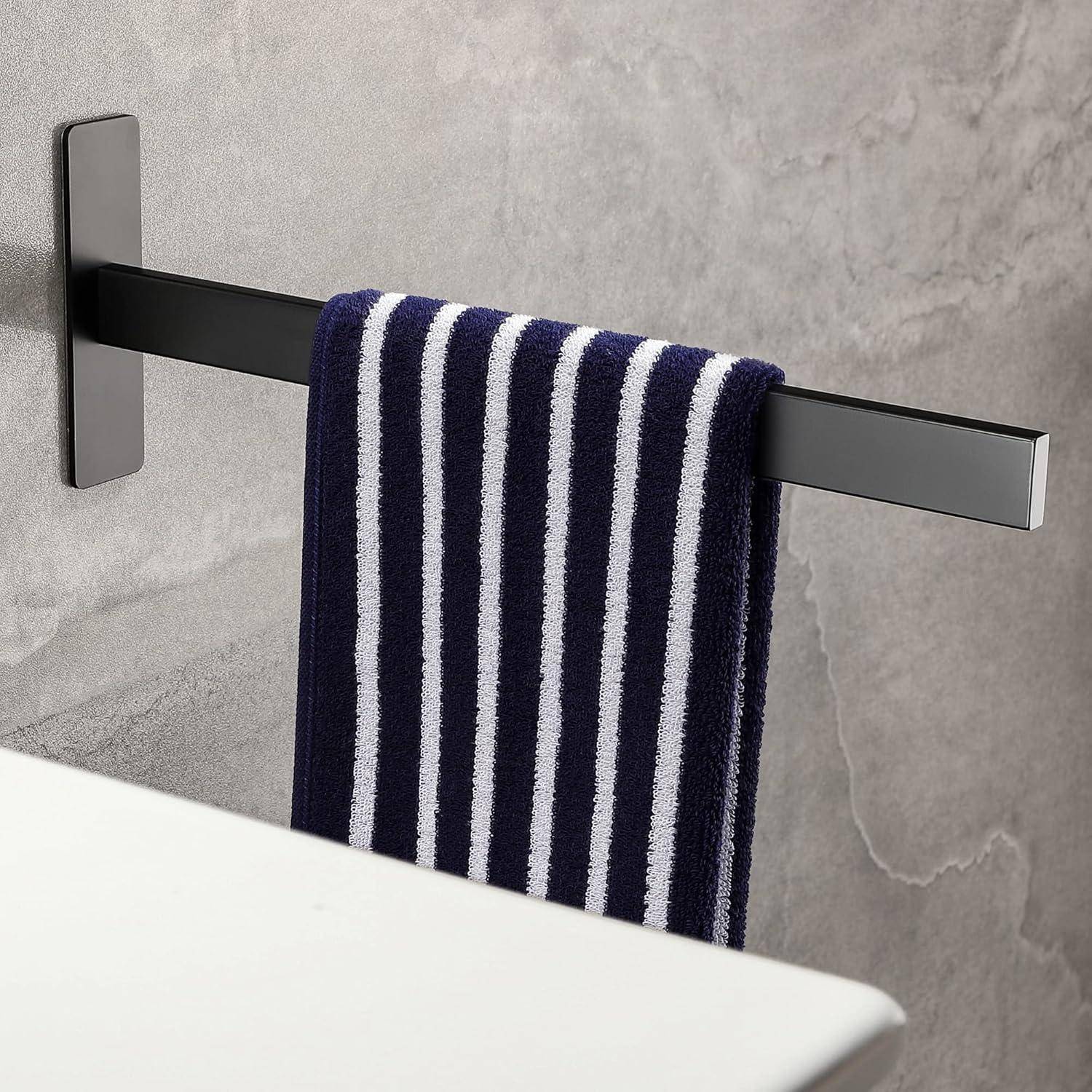 Ein gestreiftes Navy-blau und weißes Handtuch hängt ordentlich an einer modernen, schwarzen Wandhalterung für Handtücher vor einer grauen gefliesten Badezimmerwand.
