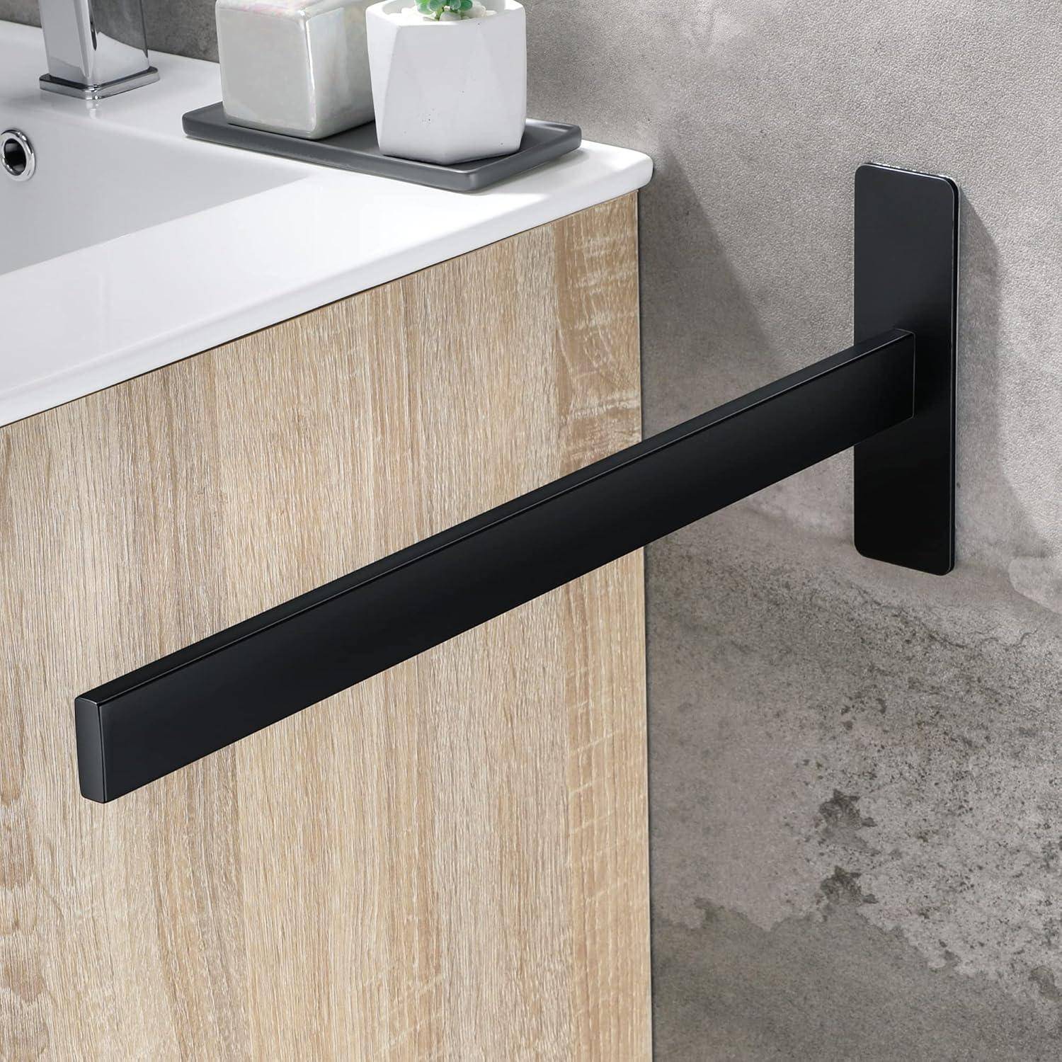 Eine schwarze Handtuchstange ist an einem modernen Badezimmerwaschtisch aus hellem Holz neben einem Waschbecken montiert, mit kleinen Pflanzen auf der Arbeitsplatte.