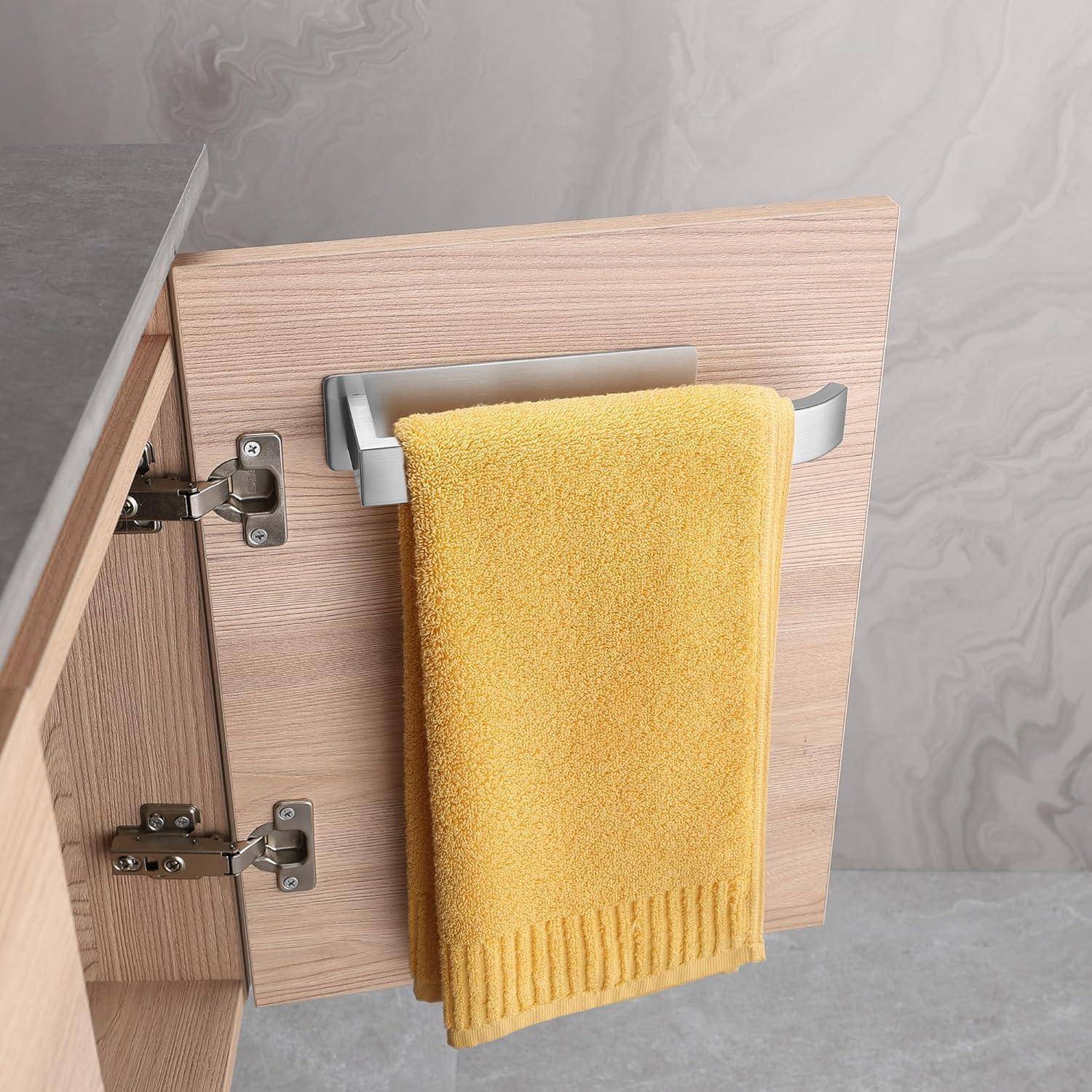 Eine Holzschranktür leicht geöffnet, mit einem gelben Handtuch, das an einem silbernen Griff hängt, wobei metallene Scharniere und ein marmorierter Wandhintergrund zu sehen sind.