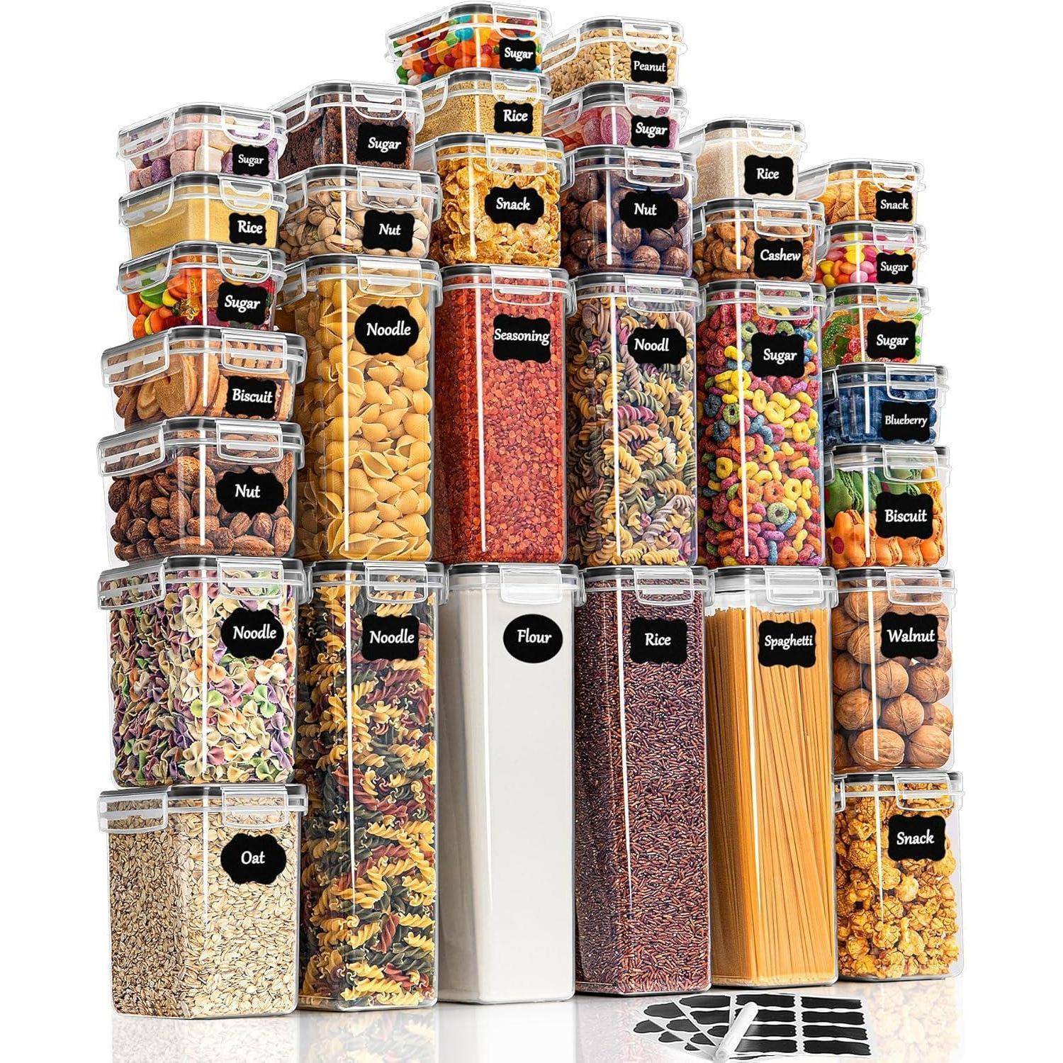 Ein Stapel beschrifteter luftdichter Behälter, die verschiedene Trockenlebensmittel wie Reis, Pasta, Müsli, Nüsse und Mehl nach Sorte organisiert enthalten.