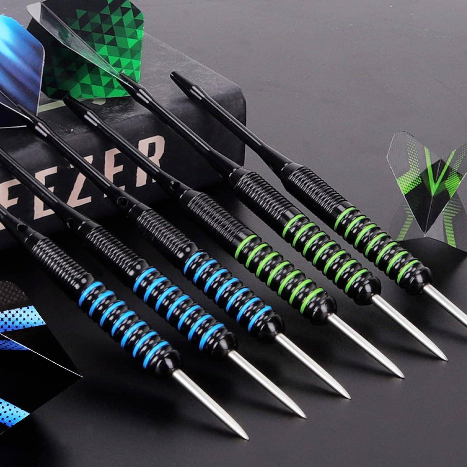 Sechs Metallpfeile mit gestreiften Griffen, drei in Blau und drei in Grün, sind auf einer reflektierenden Oberfläche in der Nähe einer teilweise sichtbaren Dartscheiben-Verpackung ausgelegt.