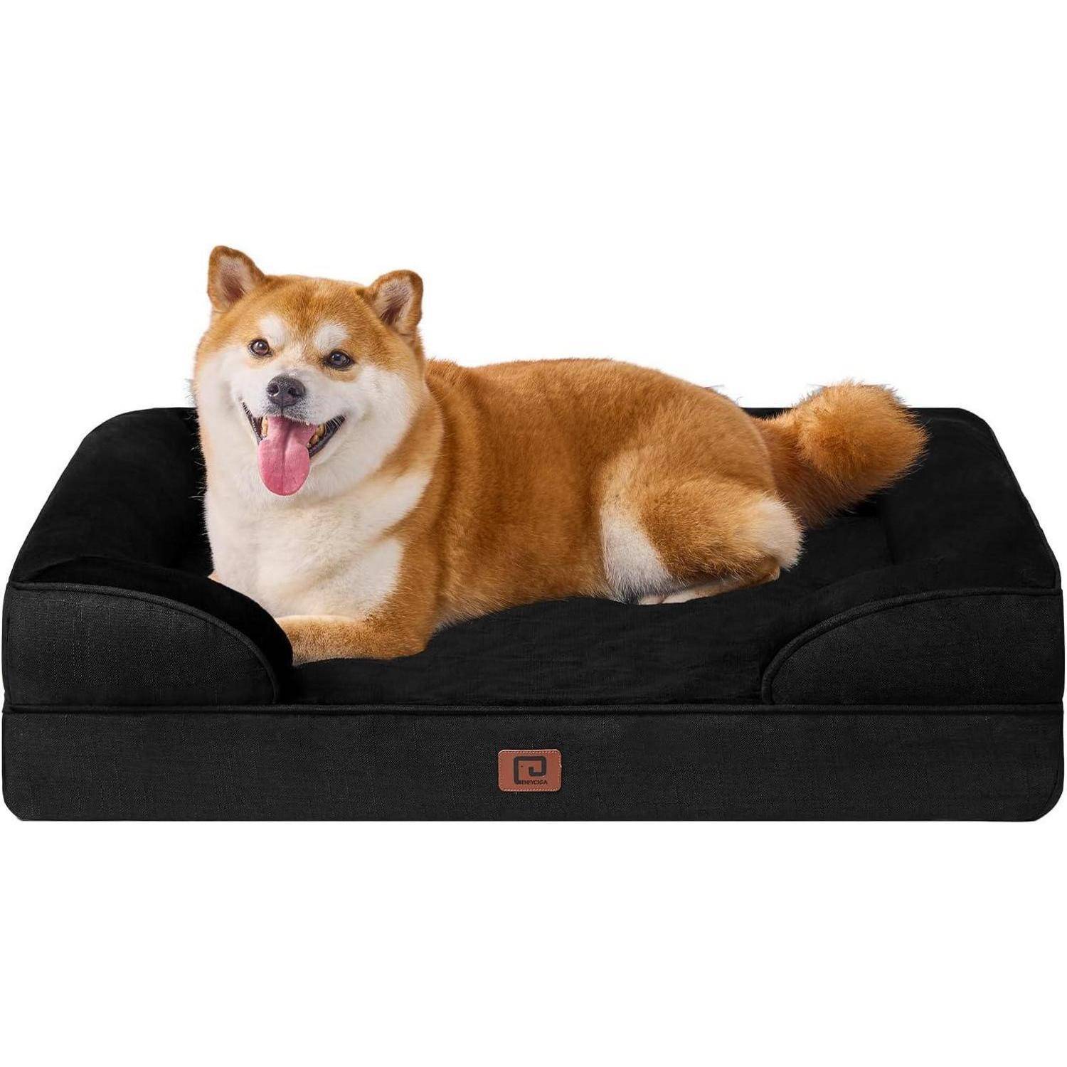 Ein lächelnder Hund mit einem flauschigen beige-weißen Fell liegt gemütlich auf einem strukturierten schwarzen Tierbett und blickt nach vorn.