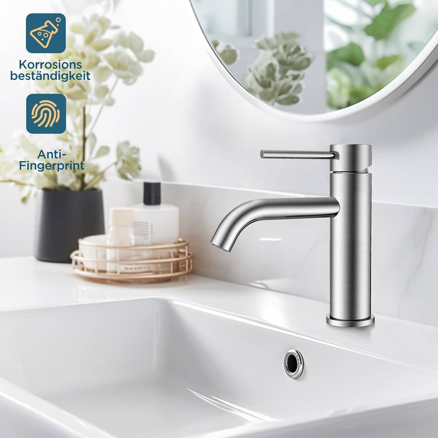 Ein modernes Badezimmerwaschbecken mit einem eleganten, silbernen Wasserhahn, der mit 'Korrosionsbeständigkeit' und 'Anti-Fingerprint' gekennzeichnet ist, mit Pflanzen und Toilettenartikeln im Hintergrund.