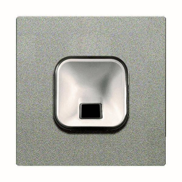 Ein quadratischer metallischer Fingerabdruckscanner mit einer vertieften, glatten Zentralfläche und einem kleinen rechteckigen Sensor am unteren Mittelpunkt.