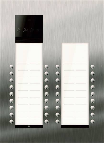 Ein Gegensprechanlagesystem mit zwei Spalten von Tasten auf einem Metallpanel, jeweils neben einer Liste mit Namen oder Bezeichnungen, das für den Gebäudezugang verwendet wird.