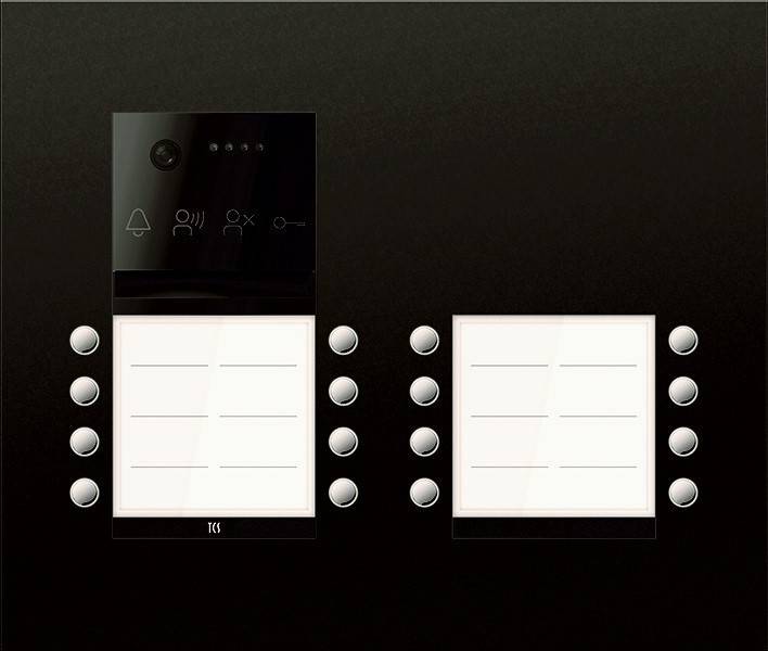 Gegensprechanlage mit Kamera, Mikrofon und Türklingel-Symbol. Zwei Reihen leerer Namensschilder mit Tasten an jeder Seite.