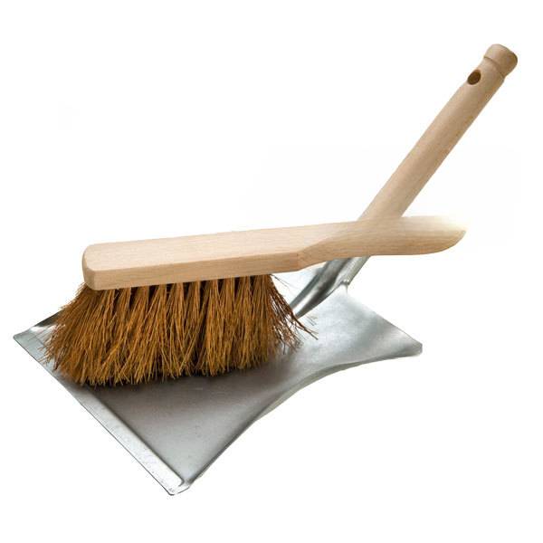 Bürste mit Holzgriff, die auf einer Metallkehrschaufel ruht, Reinigungswerkzeugsatz isoliert auf weißem Hintergrund.