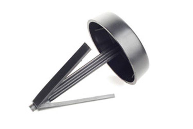 Eine abstrakte Skulptur mit einem zylindrischen Oberteil und mehreren dünnen Stäben, die in verschiedenen Winkeln nach unten ragen.