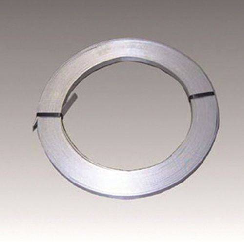 Ein aufgewickeltes Metallband liegt auf einer ebenen Oberfläche und bildet eine kreisförmige Gestalt.