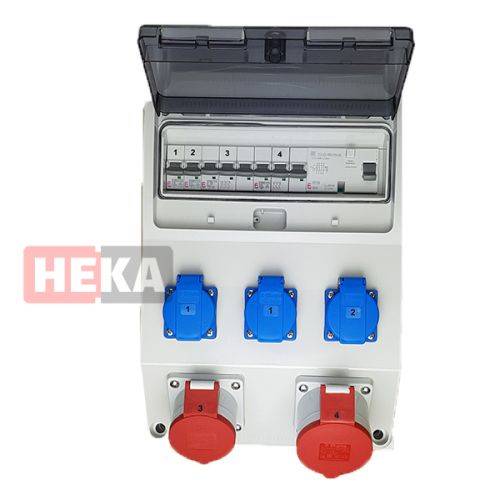 Elektrische Verteilerdose mit transparentem Deckel, auf dem beschriftete Sicherungsautomaten und fünf Steckdosen - zwei rote und drei blaue - zu sehen sind.