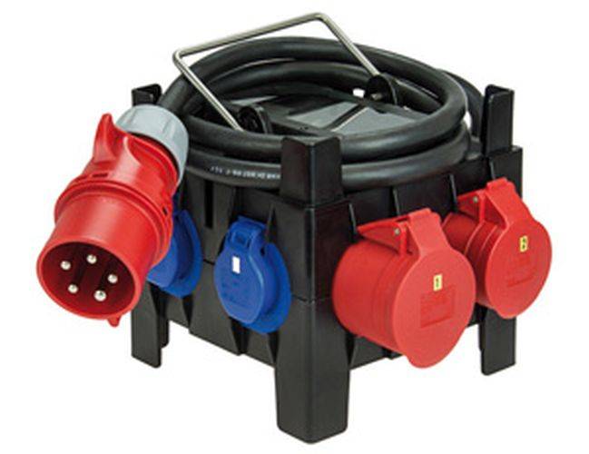 Eine schwarze Stromverteilerdose mit mehreren roten und blauen industriellen Steckdosen und einem aufgerollten Kabel oben, die zur elektrischen Verbindung verwendet wird.