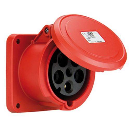 Eine rote industrielle Steckdose mit offener Schutzabdeckung, die kreisförmige Schlitze zur Steckereinführung zeigt. Montiert auf einer Wandplatte.