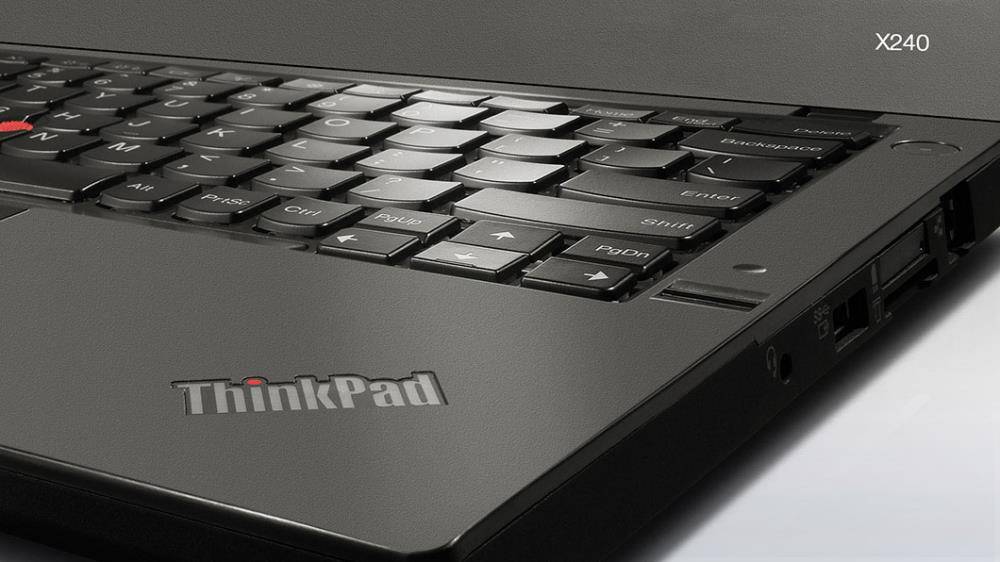 Eine Nahaufnahme einer Laptop-Tastatur mit sichtbarem 'ThinkPad' Logo, die die schwarzen Tasten und den roten Trackpoint hervorhebt und einen Arbeitskontext andeutet.