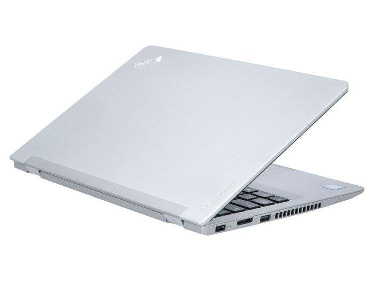 Ein silberner Lenovo-Laptop ist teilweise geöffnet und so gewinkelt, dass die Anschlüsse an seiner Seite zu sehen sind. Die Lenovo- und ThinkPad-Logos sind auf dem Deckel sichtbar.