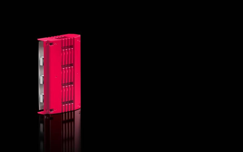 Eine glänzende, rote, rechteckige industrielle Komponente mit vertikalen Rillen, die aufrecht vor einem schwarzen Hintergrund steht und das Licht reflektiert.