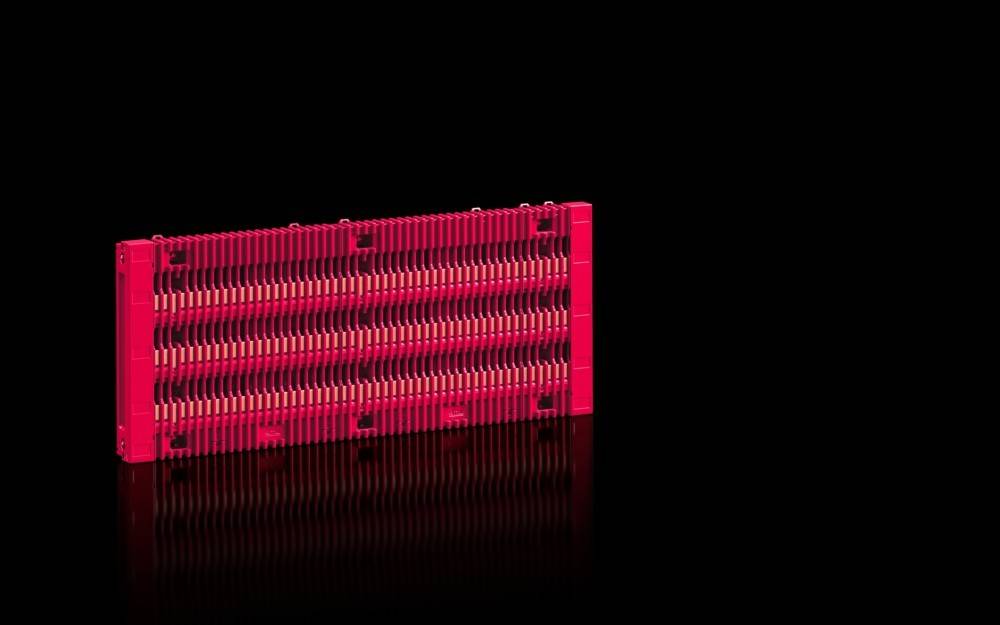Ein roter und schwarzer Computer-RAM-Riegel steht aufrecht vor einem schwarzen Hintergrund und präsentiert seine detaillierte Schaltkreis- und Komponentenstruktur.