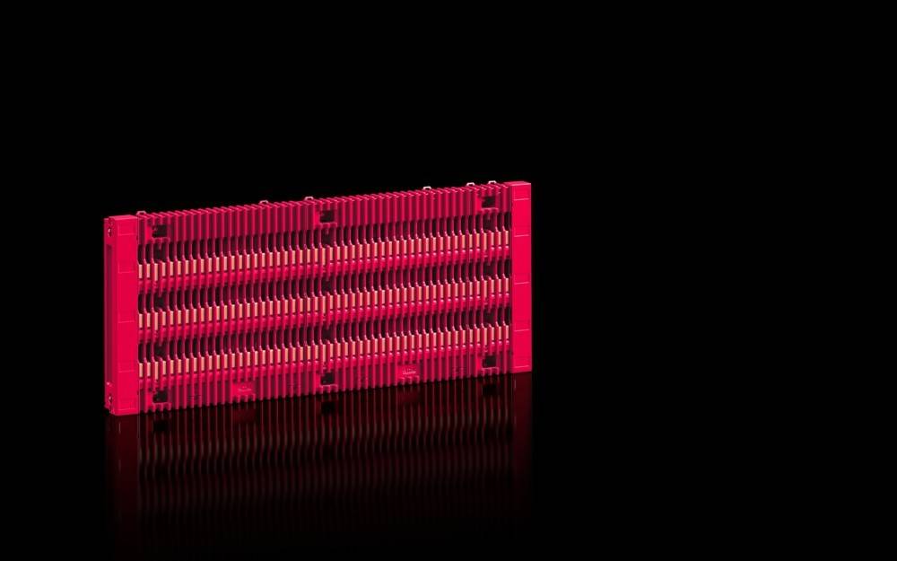 Eine rote und schwarze Computer-RAM-Modul auf einem schwarzen Hintergrund, die Rillen und Schaltkreise zeigt und Technologie und Computer-Hardware symbolisiert.