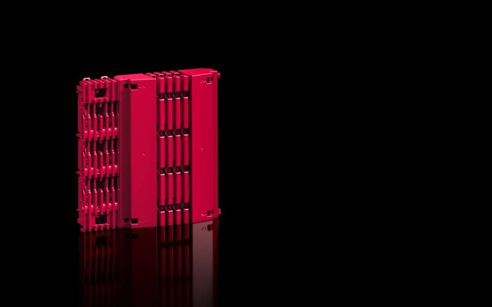 Ein Stapel roter Aktenordner mit Faltenrücken steht vor einem schwarzen Hintergrund und spiegelt sich leicht auf der Oberfläche darunter, wodurch die Organisation betont wird.