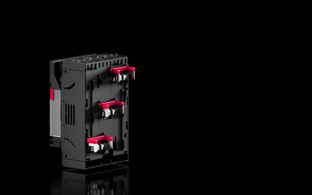 Eine schwarze Computergehäuse-Komponente mit drei montierten roten und schwarzen Griffen, wahrscheinlich für die Installation oder Entfernung von Laufwerken verwendet.