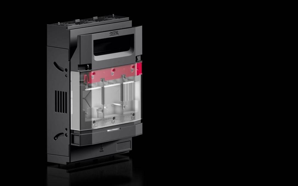 Eine schwarze und silberne elektrische Gehäuse mit transparenten und roten Abschnitten, die interne Mechanismen zeigen, vor einem dunklen Hintergrund.