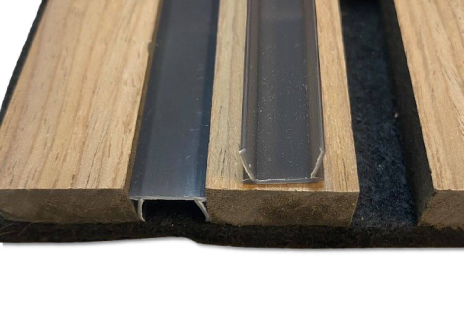 Eine Nahaufnahme von zwei Übergangsleisten auf Laminatboden, die verschiedene Profile zeigen: eine aus Metall und eine aus transparentem Kunststoff.