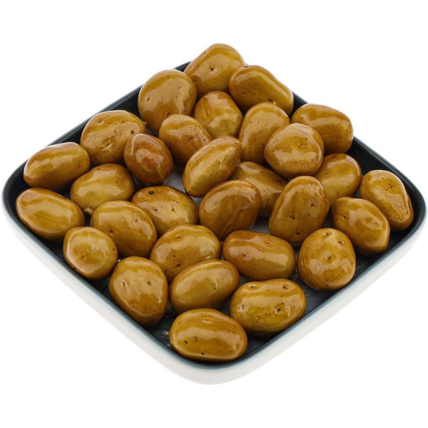 Eine quadratische Schale, gefüllt mit glasierten, runden Karamellbonbons, ordentlich in Reihen angeordnet.