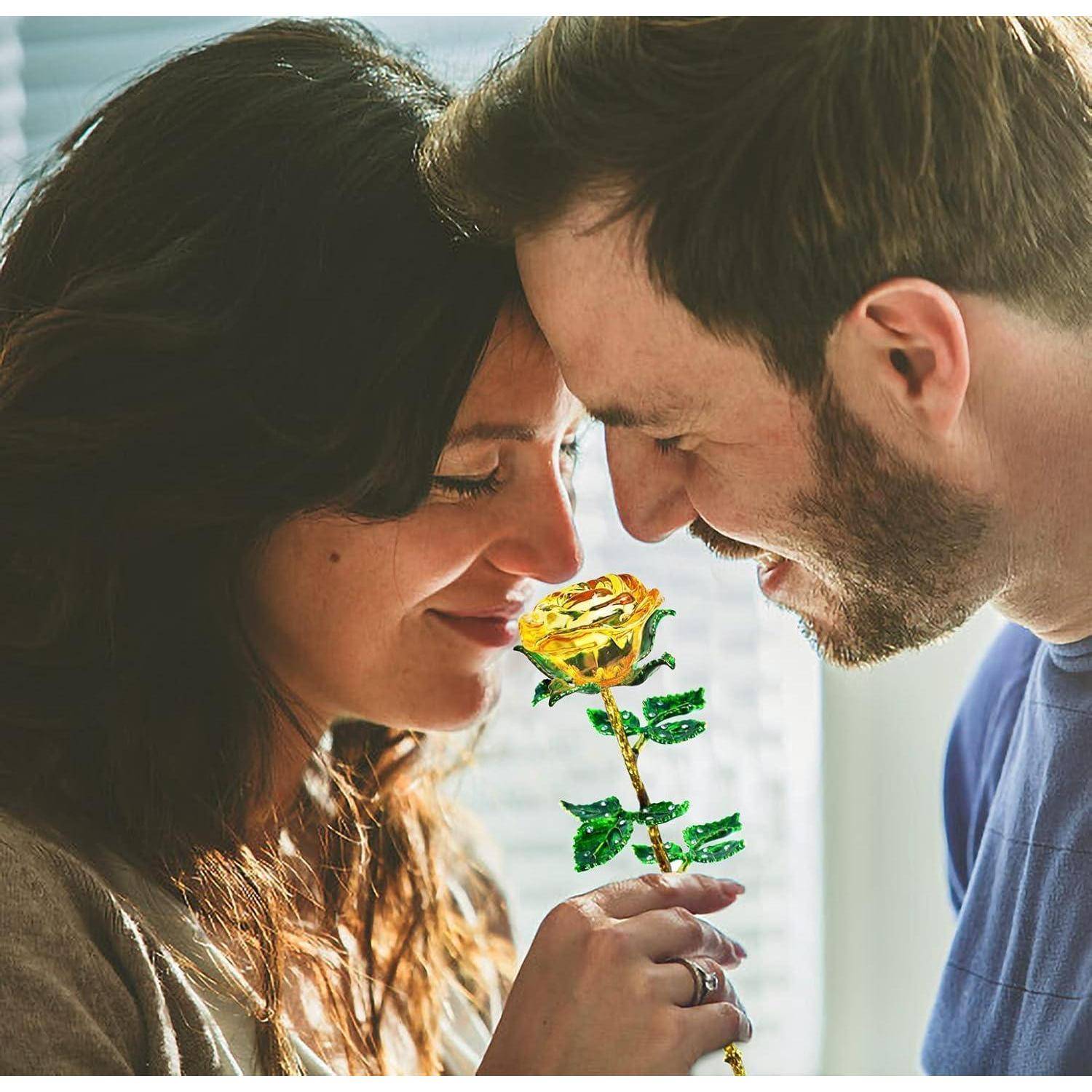 Ein Mann und eine Frau teilen einen zärtlichen Moment, lächeln mit Köpfen nah beieinander, während die Frau eine gelbe Rose hält.