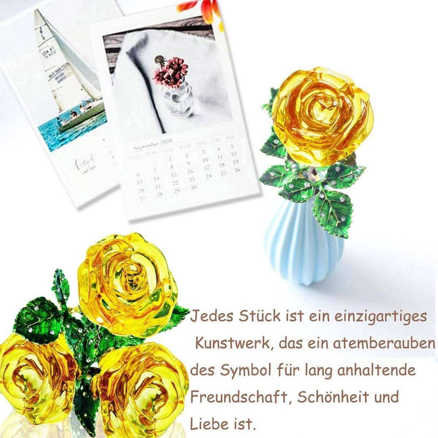 Eine gelbe Kristallrose in einer blauen Vase steht neben einem Kalender und Karten. Der deutsche Text beschreibt die Rose als Symbol der Freundschaft und Schönheit.