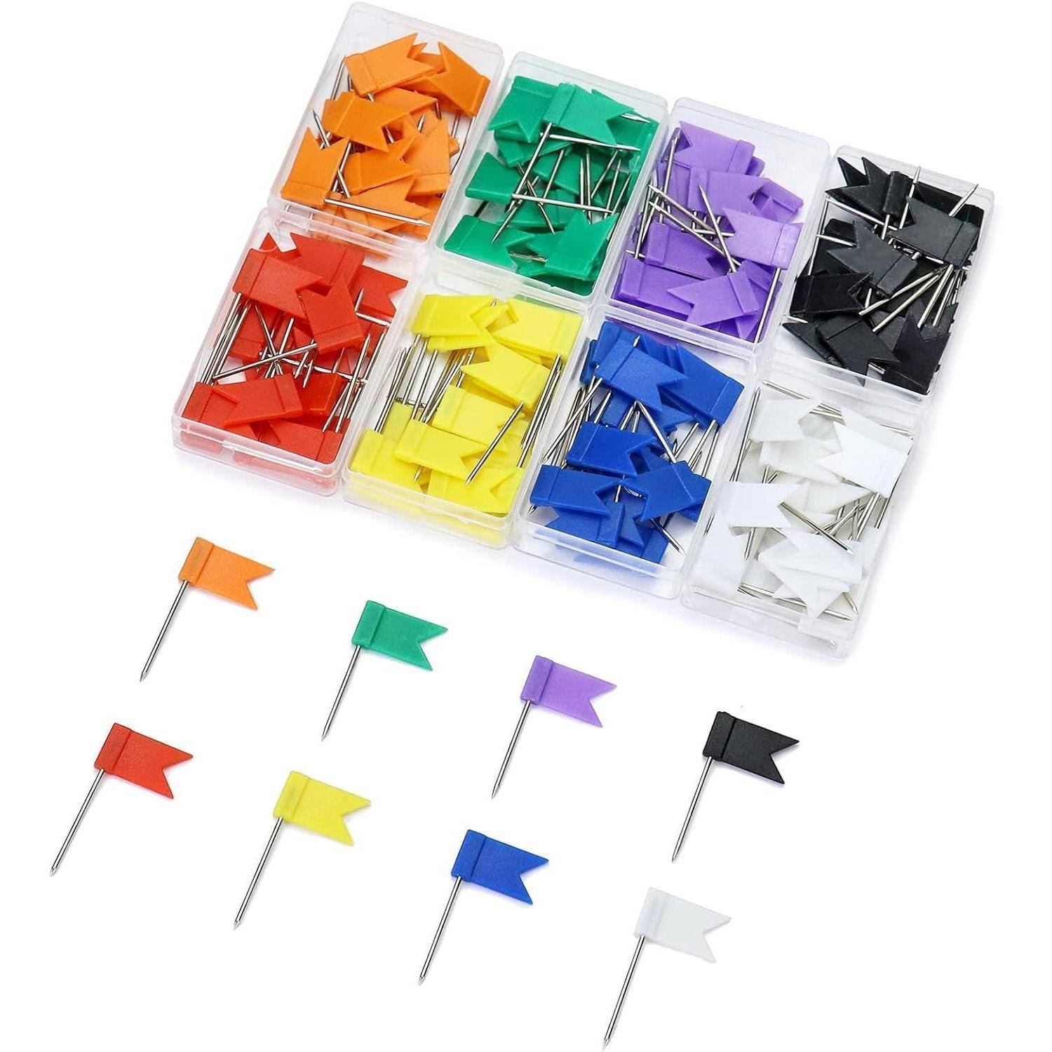 Eine bunte Schachtel mit Flaggennadeln in verschiedenen Farben, darunter Orange, Rot, Gelb, Grün, Blau, Lila, Schwarz und Weiß, angeordnet in sieben Behältern.