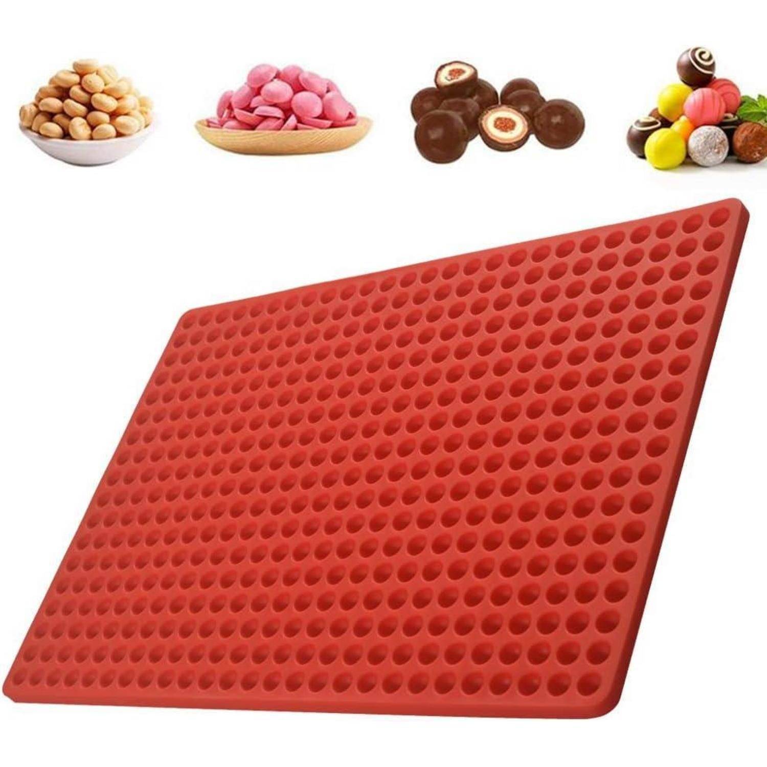 Rote Silikonbackmatte mit mehreren kleinen runden Förmchen; darüber platziert sind Beispiele verschiedener Snacks wie Nüsse und Süßigkeiten.