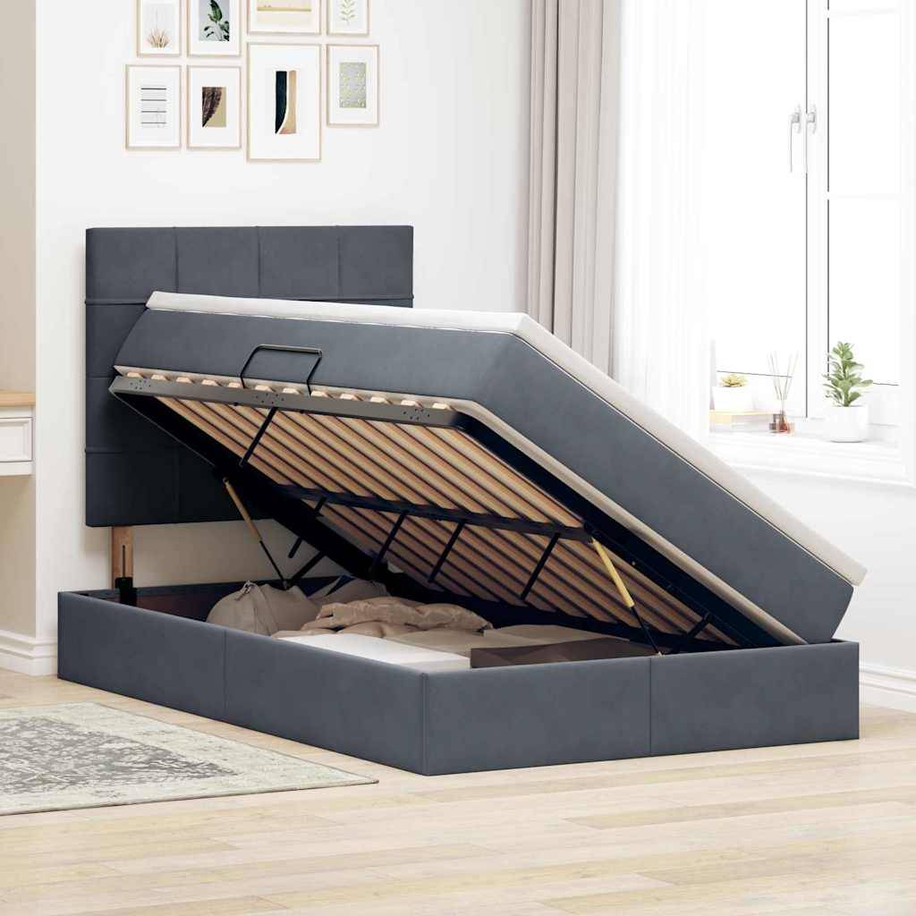 Ein Bett mit angehobener Matratze offenbart Stauraum darunter. In der Nähe bringt ein Fenster mit geschlossenen Vorhängen Licht in das ordentliche Zimmer.