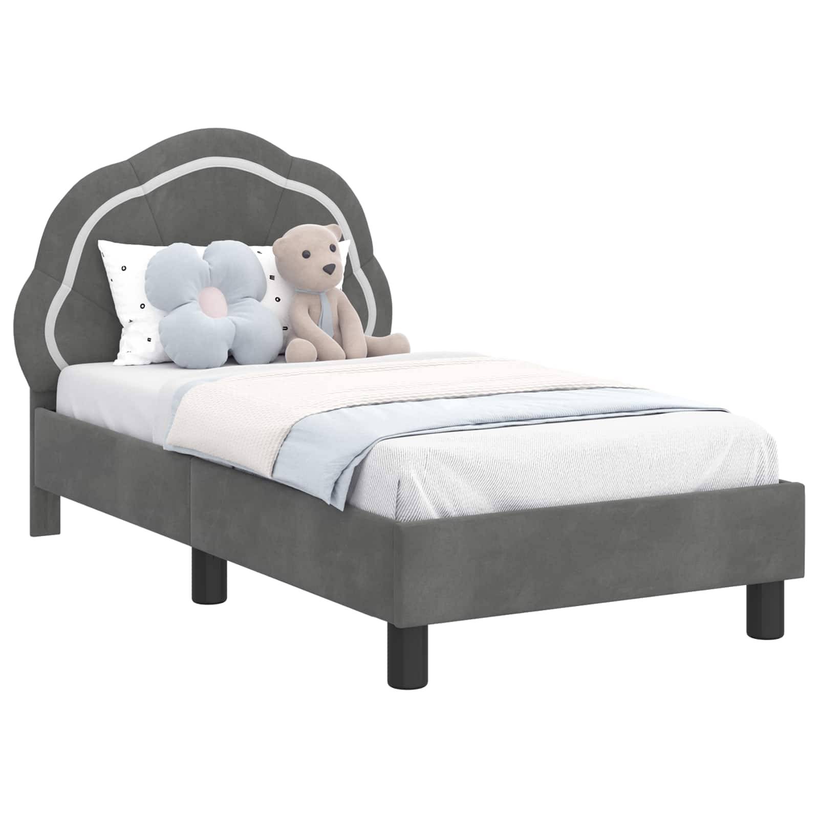 Ein graues Bett mit einer gewellten Kopfleiste, weiß-hellblauer Bettwäsche und dekorativen Kissen, darunter ein Teddybär und eine Blumenform.