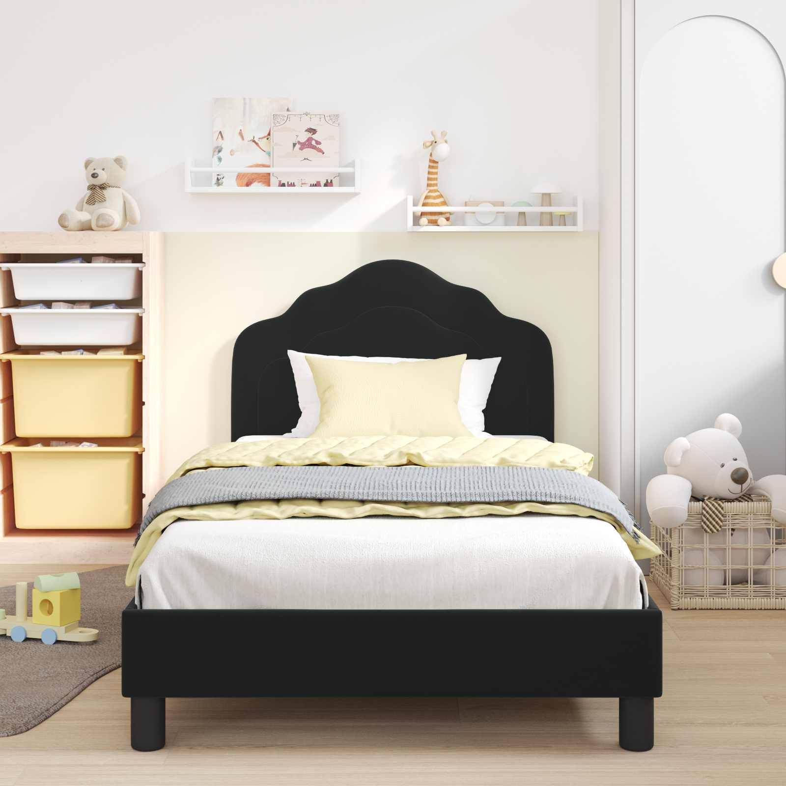 Ein Kinderzimmer mit einem schwarzen Kopfteilbett, gelber und grauer Bettwäsche, Spielzeug-Aufbewahrungskisten und Regalen mit einem Teddybären und anderen Spielsachen.