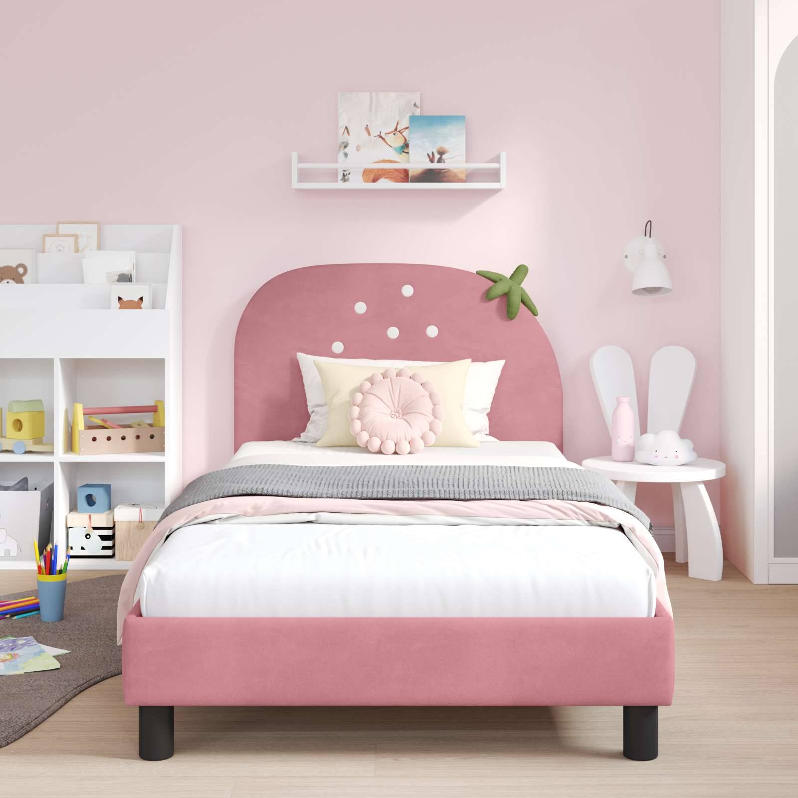 Kinderzimmer mit einem rosa Bett, grau-weißer Bettwäsche und einem pastellfarbenen Dekor-Thema. Ein Bücherregal und ein kleiner Tisch mit einer Lampe befinden sich im Hintergrund.