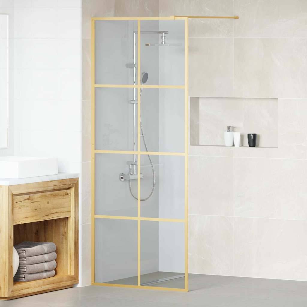 Ein modernes Badezimmer verfügt über einen Waschtisch aus Holz mit gestapelten Handtüchern, eine Dusche mit Glaswänden und goldenem Rahmen und beige geflieste Wände.