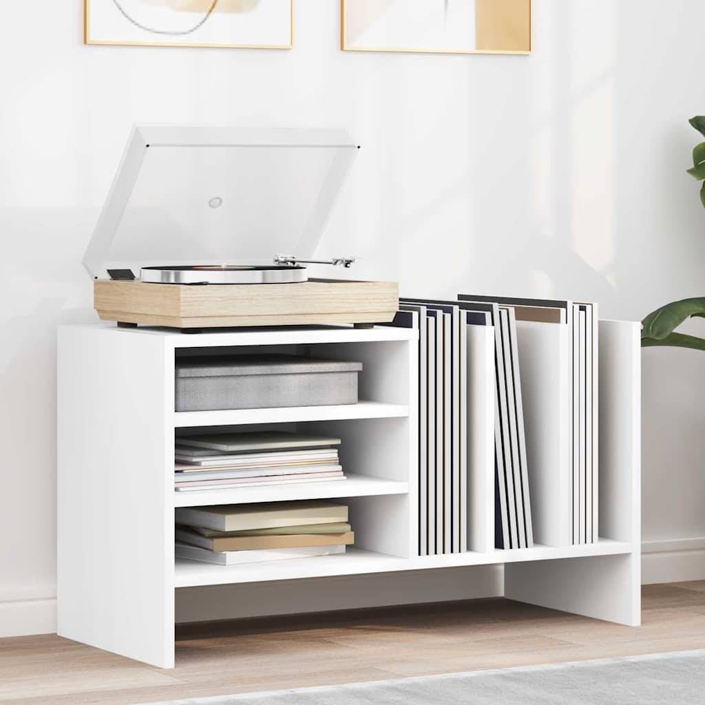Eine weiße moderne Aufbewahrungseinheit trägt einen Plattenspieler oben, Schallplatten aufrecht stehend auf der rechten Seite und Bücher gestapelt auf den linken Regalen.
