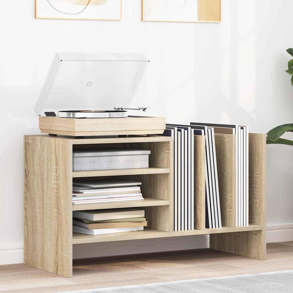 Ein Schallplattenständer aus Holz mit Regalen, der eine Plattenspieler, Schallplatten und Zeitschriften trägt, steht vor einer hellgefärbten Wand mit gerahmter Kunst.
