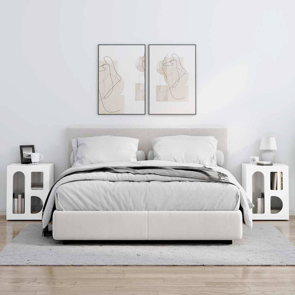 Ein modernes Schlafzimmer mit einem ordentlich gemachten Bett mit weißer und grauer Bettwäsche, flankiert von zwei minimalistischen Nachttischen und abstrakter Kunst an der Wand.