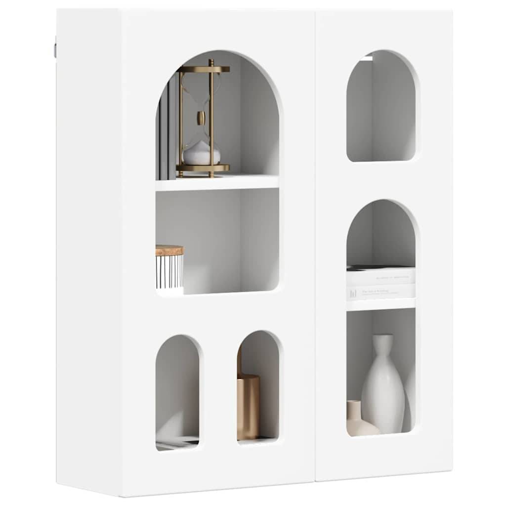 Weißes Wandregal mit Bogendurchbrüchen, die dekorative Gegenstände wie eine Vase, Bücher, eine Kerze und eine Laterne auf seinen Regalen freilegen.