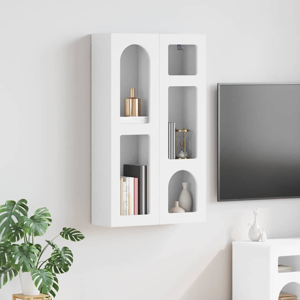 Ein moderner weißer Wandschrank mit Regalen, auf denen Bücher und Dekorationsgegenstände ausgestellt sind, neben einem Flachbild-Fernseher und einer weißen Vase auf einem Tisch.