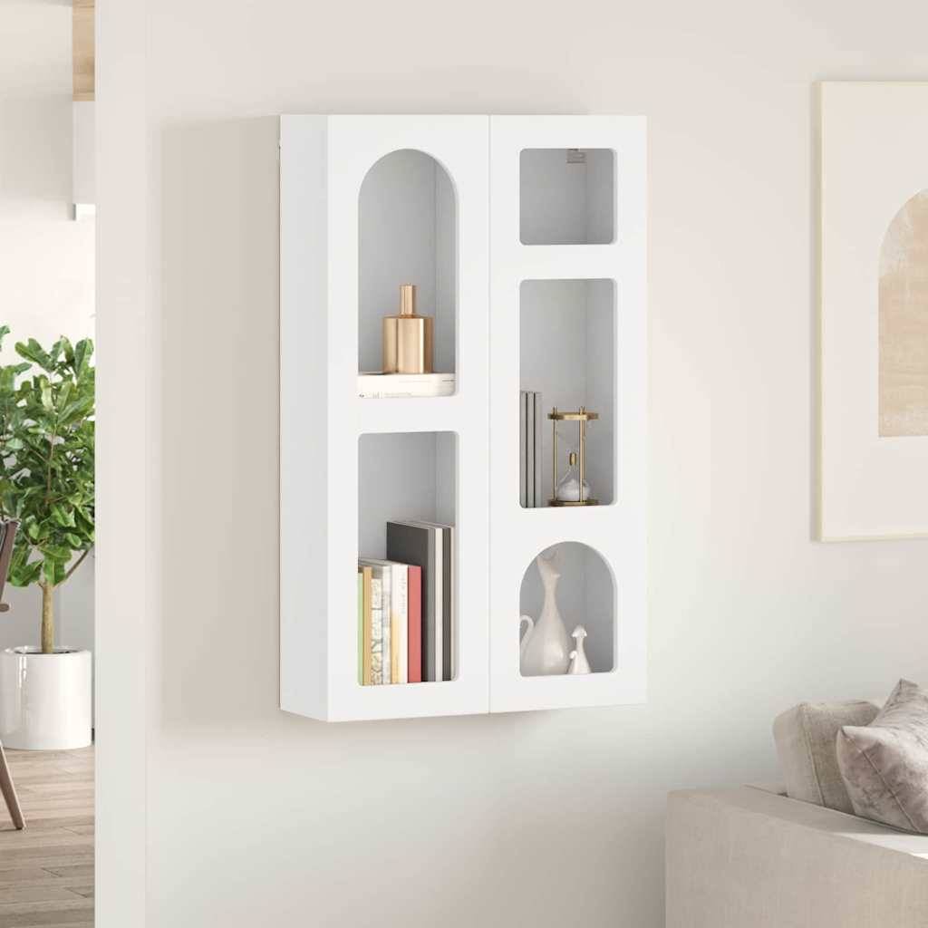 An der Wand montiertes weißes Regal mit dekorativen Bögen, bestückt mit Büchern, einer Pflanze und kleinen Dekorationsgegenständen, platziert in einem modernen, neutral gehaltenen Raum.